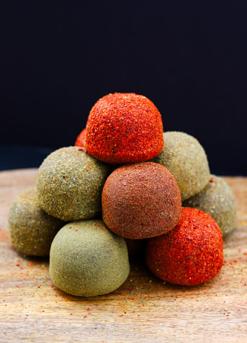 Stack of feta cheese balls on a wooden board.