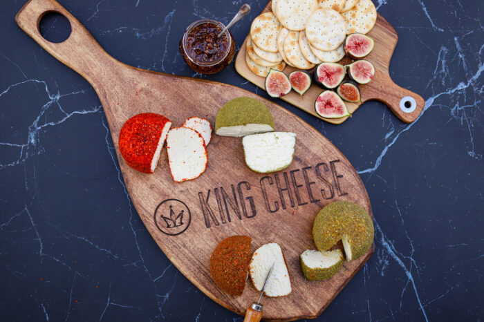 Feta cheese on a King Cheese wooden cutting board and crackers and fruit on a little cutting board with jam.